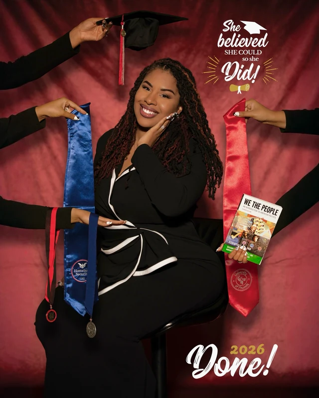 Keira celebrating graduation with a cap, honors stoles, and a book against a red studio backdrop