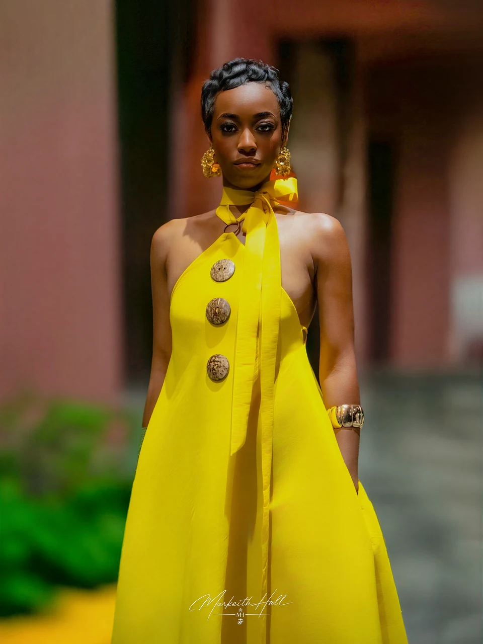 A woman in a bright yellow dress with wooden buttons at Orlando International Fashion Week