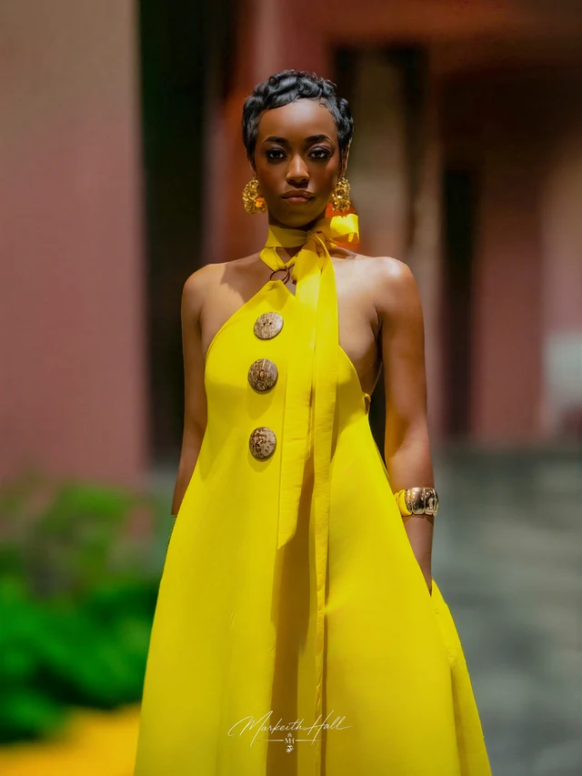 A woman in a bright yellow dress with wooden buttons at Orlando International Fashion Week