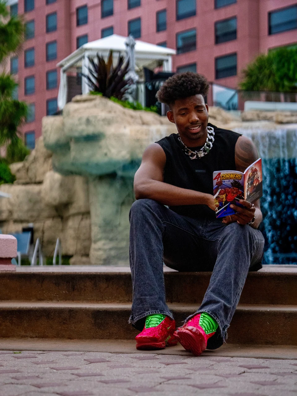 A man reading a 4 Corners comic beside a fountain
