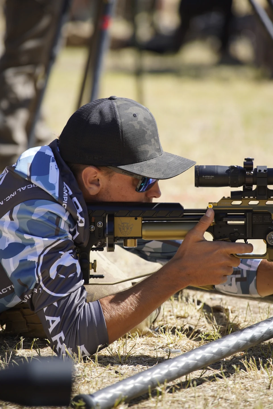 An airgun competitor concentrates through his rifle scope from a prone position at RMAC 2024
