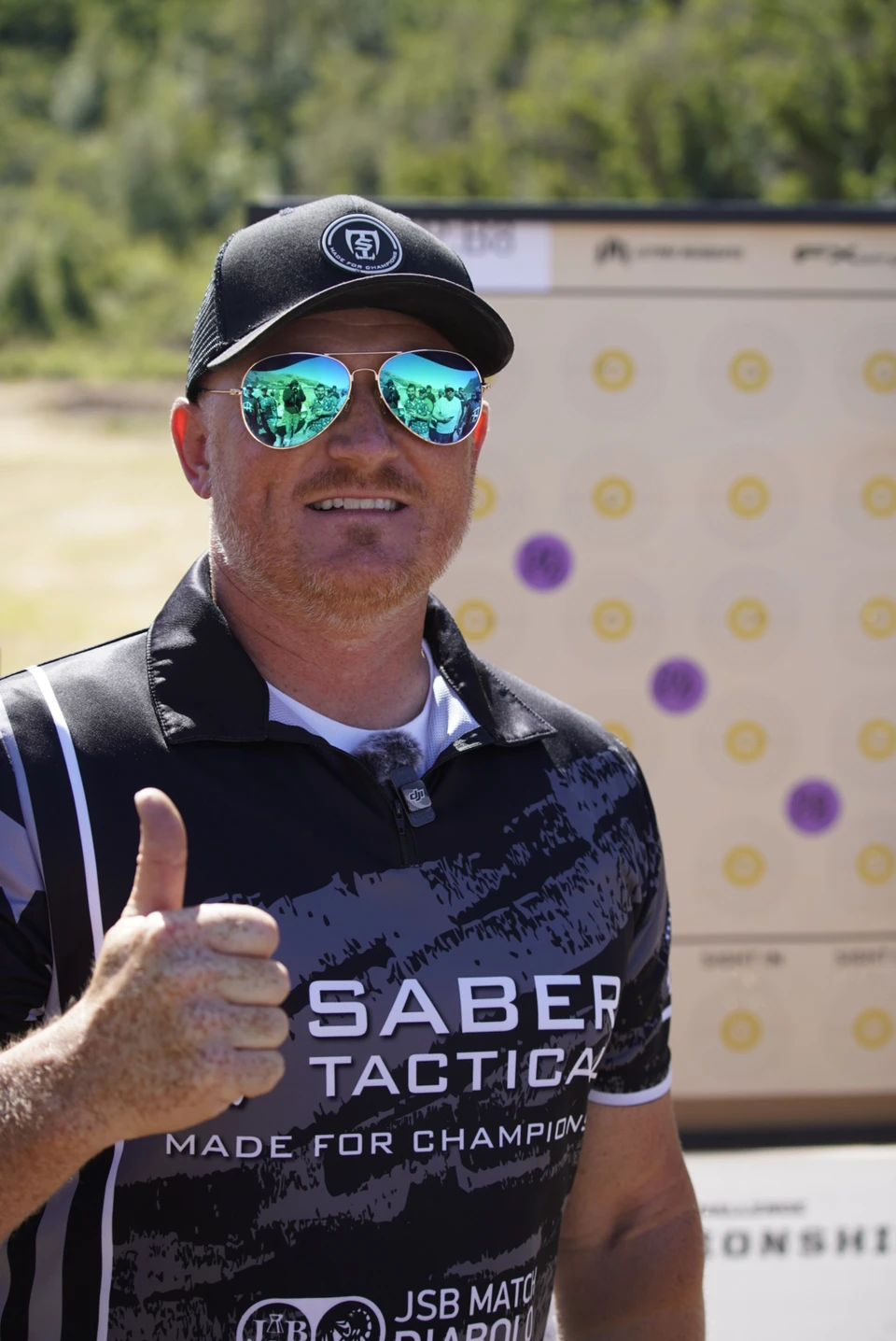 A Saber Tactical competitor gives a thumbs-up beside a target card at RMAC 2024